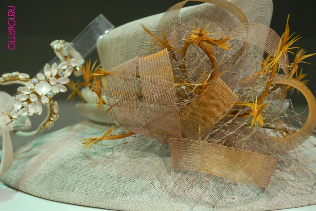 Osvaldo Rossi for Il Tacco dresses you with this jewel sandal in light beige patent with flower-shaped stones. Mar Cano signs this noble hat with a beautiful sinamay round base and doublé flounce around crinoline crown,  decorated also with crioline and french netting.