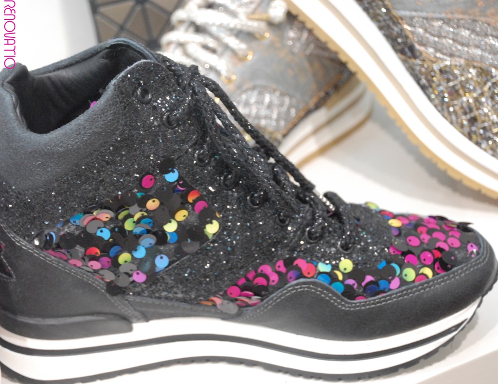 IL TACCO. 2STARGOLD. Revolucionarias zapatillas deportivas de caña alta en piel negra con efecto envejecido y lentejuelas multicolor. La purpurina negra está incrustada. Con apliques de estrellas en el talón. Cordones laminados en negro con puntas en níquel metalizado. Suela de goma bicolor en blanco marfil y negro con caucho alrededor del talón. Plantilla ergonómica cubierta por una cuña de 4.5cm de piel de becerro. 